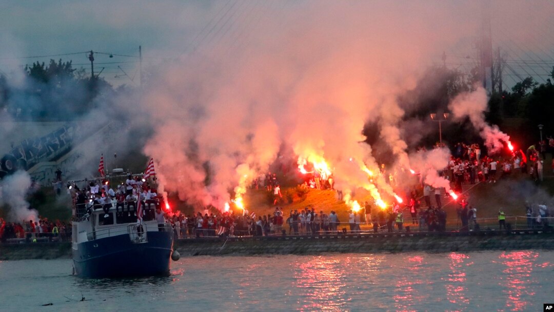 Brod sa fudbalerima plovi rekom Savom, dok navijači Crvene zvezde proslavaljaju titulu, u Beogradu, Srbija, 22. maja 2021. (Foto: AP, Darko Vojinović)