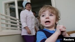 Adoption candidate Mark, 2, reacts in the children's department of a local hospital in Russia's Siberian city of Krasnoyarsk, March 23, 2011.