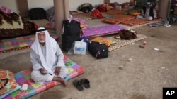 FILE - A Mosul residents is seen sitting on the ground on the premises of a mosque close to the frontline with the Islamic State group, in Kirkuk, Iraq, Oct. 14, 2015.