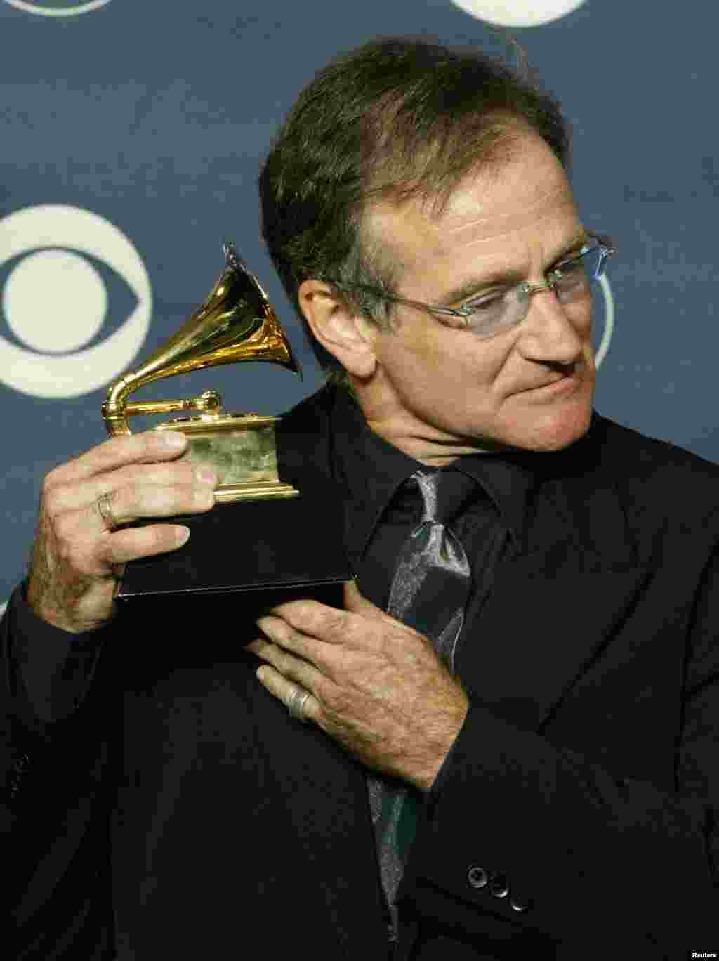 Comedian Robin Williams holds his Grammy Award to his ear as he poses for photographers at the 45th annual Grammy Awards at New York&#39;s Madison Square Garden, Feb. 23, 2003. Williams won the Grammy for Best Spoken Comedy Album for &quot;Robin Williams Live 2002.&quot;