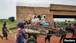 FILE - A Chadian cart owner transports belongings of Sudanese people who fled the conflict in Sudan's Darfur region, while crossing the border between Sudan and Chad in Adre, Chad August 4, 2023. 