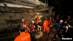FILE - A rescue team searches for trapped workers at a collapsed building that was under construction in Kep, Cambodia, Jan. 3, 2020. 