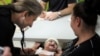 FILE - A doctor examines a cleft-lipped baby during a medical evaluation provided by Operation Smile volunteers at San Felipe hospital in Tegucigalpa November 14, 2012.