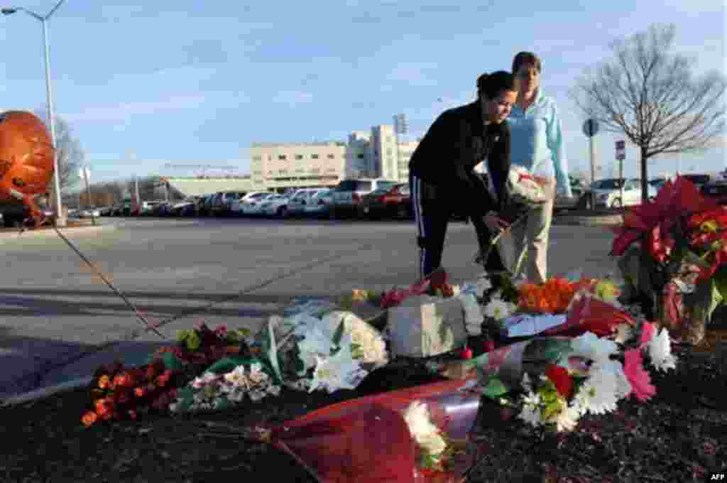 Flowers are placed on the ground by Virginia Tech students, Annie Bryce (sophomore) and her sister Kelly Bryce (senior) as a memorial to Virginia Tech police Officer Deriek Crouse who was gunned down Thursday during a traffic stop on the campus of Virgini