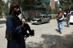 FILE - Taliban fighters stand guard at a checkpoint in the Wazir Akbar Khan neighborhood in the city of Kabul, Afghanistan, Aug. 18, 2021.