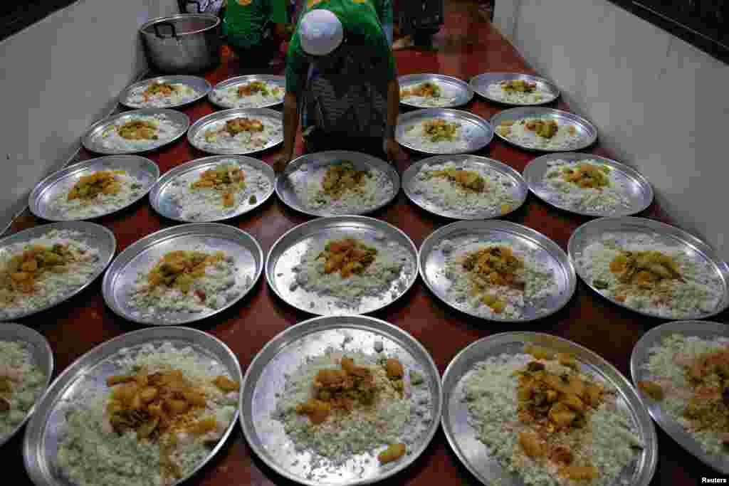 Seorang imigran ilegal Muslim Rohingya mempersiapkan hidangan berbuka puasa di Pusat Penahanan Imigrasi di provinsi Kanchanaburi, Thailand (10/7).&nbsp;