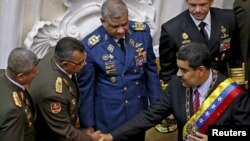 El presidente de Venezuela, Nicolás Maduro y Néstor Reverol, comandante general de la Guardia Nacional venezolana, se dan la mano durante su informe anual sobre el estado de la nación en la Asamblea Nacional de Caracas, Venezuela, el 15 de enero de 2016. 