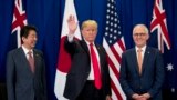 President Donald Trump, accompanied by Japanese Prime Minister Shinzo Abe, left, and Australian Prime Minister Malcolm Turnbull, right, waves to reporters at a meeting during the ASEAN Summit at the Sofitel Philippine Plaza, Monday, Nov. 13, 2017, in Mani