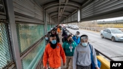 Migrants approach the U.S. border on Gateway International Bridge in Brownsville, Texas on March 2, 2021.