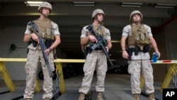 Armed soldiers guard a parking lot at the Navy Yard in Washington, Thursday, July 2, 2015. The Washington Navy Yard was on lockdown Thursday morning after reports of gunshots, but a senior federal law enforcement official says there has been no confirmed report of any shooting. (AP Photo/Jacquelyn Martin)