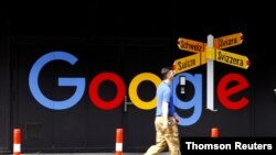 Un hombre pasa frente a una gigantografía que anuncia a Google en Zurich, Suiza.