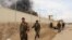 FILE - Smoke rises from a building where Taliban insurgents hid during a fight with Afghan security forces in Helmand province, Afghanistan, March 9, 2016. 
