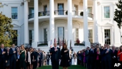 President Donald Trump and first lady Melania Trump stand as "Taps" is played to mark the anniversary of the Sept. 11 terrorist attacks, on the South Lawn of the White House, Monday, Sept. 11, 2017, in Washington.