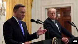 FILE - President Donald Trump, right, listens as Polish President Andrzej Duda speaks during a joint news conference in the East Room of the White House in Washington, Sept. 18, 2018.