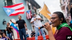 Protesters gather outside the government mansion La Fortaleza in San Juan, Puerto Rico, Wednesday, Aug. 7, 2019, calling for the removal of the island's newly sworn-in governor. 