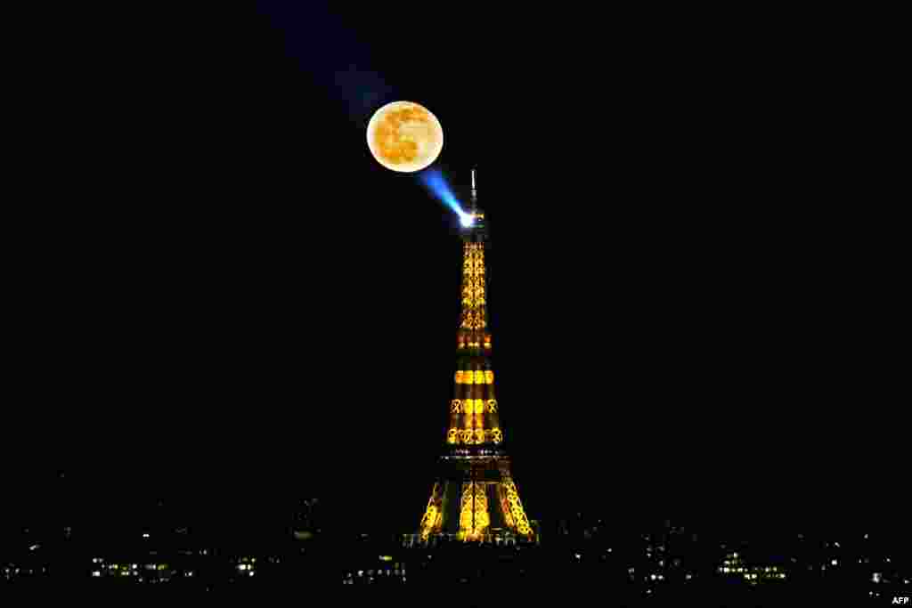 The waning gibbous moon appears in the sky following the weekend's full "Snow Moon", near the Eiffel Tower in Paris, France, Feb. 28, 2021.