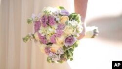 In this Thursday, Dec. 14, 2017 photo, a bride holds a bouquet during her wedding in Ein Hemed. A growing number of Israeli couples are defying the country’s Chief Rabbinate and marrying in unsanctioned weddings. The couples include people who have…