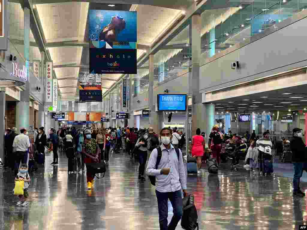 Los viajeros de la temporada navide&#241;a atraviesan una terminal en el Aeropuerto Internacional de Miami el 24 de diciembre de 2020 en Miami, Florida.