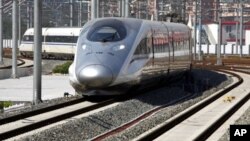 A new high-speed train arrives at the Beijing-South railway station. The landmark Beijing-Shanghai line, which costs 220.9 billion yuan and spans 1,318-km linking the capital and financial hub, is set to launch by the end of June. On the left with her bac