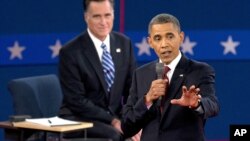 El presidente Barack Obama habla mientras el republicano Mitt Romney escucha sonriente en el fondo. Según las encuestas, Obama ganó el segundo debate.