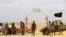 FILE - Rebels under Libyan rebel leader Ibrahim Jathran guard the entrance of the al-Ghani oil field.