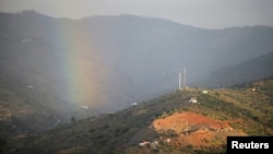 A rainbow appears over a mountain as a drill, bottom right, works where Julen Rosello, a 2-year-old Spanish boy, fell into a deep well earlier in the month when his family was taking a stroll through a private estate, in Totalan, Spain, Jan. 20, 2019.