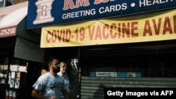 ຮ້ານຂາຍຢາແຫ່ງນຶ່ງຢູ່ໃນຄຸ້ມໃກ້ກັບແຄມຫາດຊາຍ Brighton ຊຶ່ງເປັນຄຸ້ມຢູ່ອາໄສຂອງຄົນເຊື້ອສາຍຣັດເຊຍໃນນະຄອນນິວຢອກທີ່ມີຈໍານວນຄົນຕິດພະຍາດໂຄວິດ-19 ເພີ້ມຂຶ້ນນັ້ນຕິດປ້າຍໂຄສະນາໃຫ້ຄົນໄປສັກຢາວັກຊິນກັນ Covid-19, ວັນທີ 22 ກໍລະກົດ, 2021