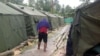 FILE - An undated photo from the Refugee Action Coalition on Feb. 18, 2014, shows a man walking between tents at Australia's regional processing center on Manus Island in Papua New Guinea. 