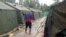 FILE - An undated photo from the Refugee Action Coalition on Feb. 18, 2014, shows a man walking between tents at Australia's regional processing center on Manus Island in Papua New Guinea. 