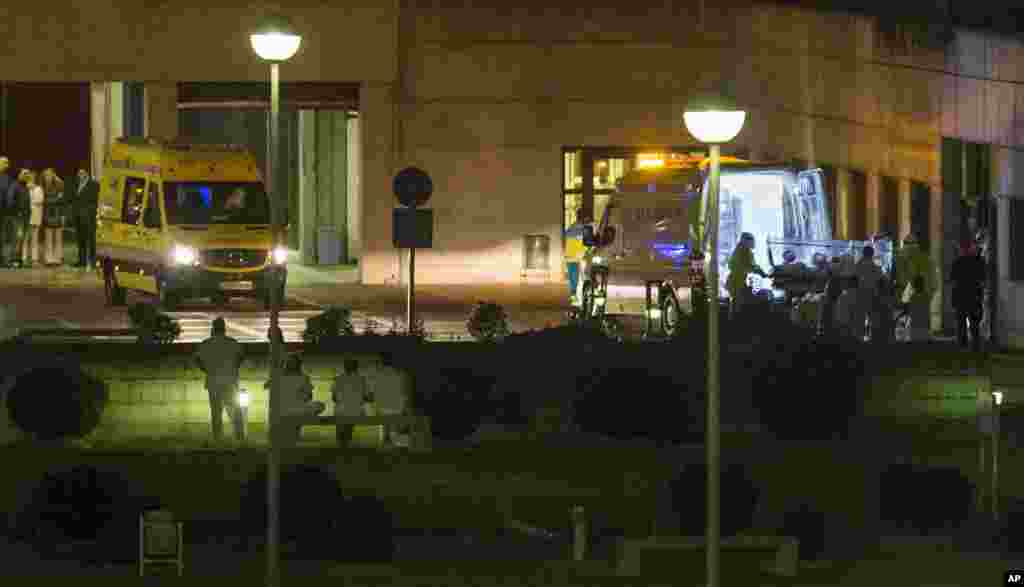 Medical personnel carry a Spanish nurse who is believed to have contracted the Ebola virus from a 69-year-old Spanish priest into the ambulance before they leave Alcorcon Hospital in Madrid, Spain, Oct. 7, 2014. 