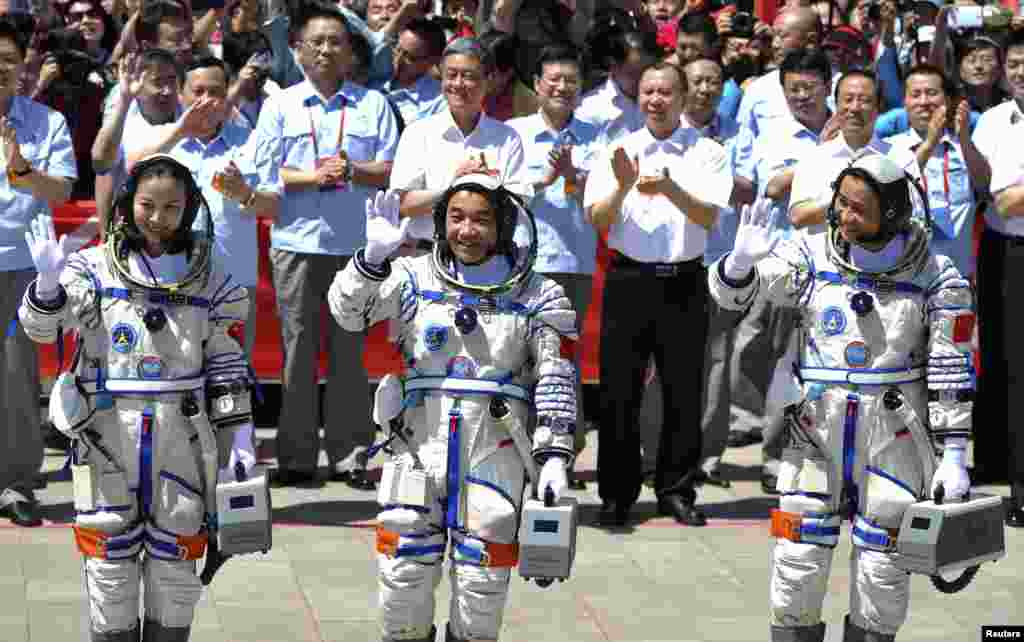 Para astronot China, dari kiri ke kanan, Wang Yaping, Zhang Xiaoguang dan Nie Haisheng melambaikan tangan sebelum berangkat untuk misi angkasa luar berawak Shenzhou-10 dari provinsi Gansu (11/6). (Reuters/China Daily)