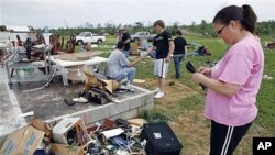 Carla Arenda tente de récupérer quelques effets personnels sur les ruines de sa maison à Vilonia, dans l'Arkansas