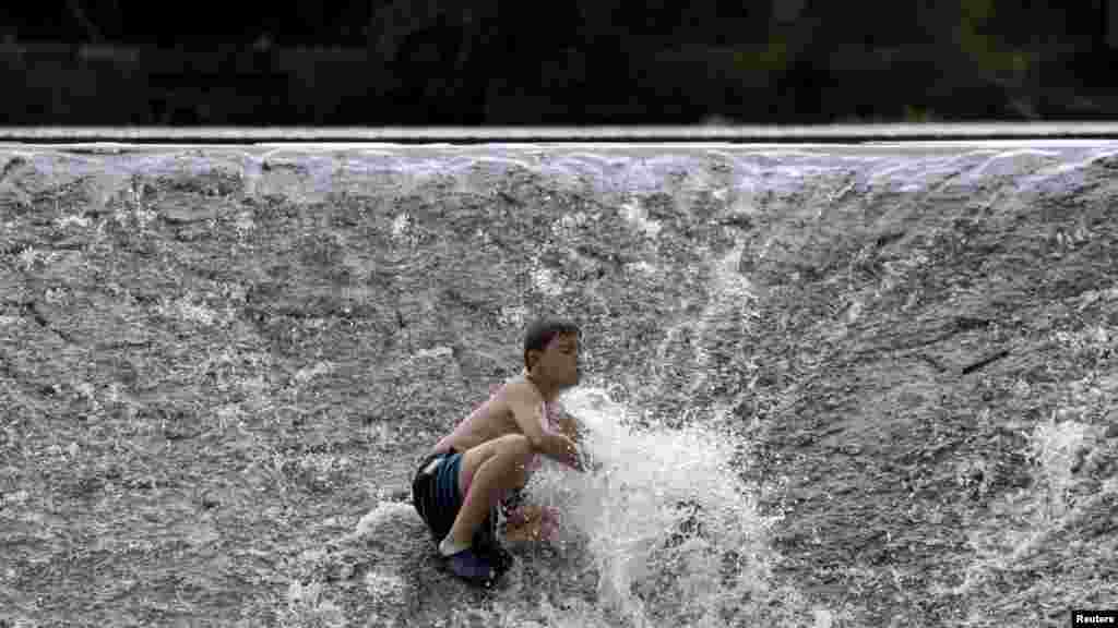 Seorang anak mencipratkan air di sungai Berounka di saat temperatur mencapai 37 derajat Celcius di desa&nbsp;​Zadni Treban dekat Praha, Republik Ceko.