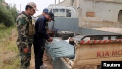 Free Syrian Army fighters stand near mortar shells on a truck in Khirbet Ghazaleh, Daraa, May 3, 2013. 