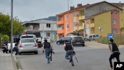 伊斯坦布尔一个警察局附近发生枪战，土耳其警察跑向隐蔽物。 （2015年8月10日）