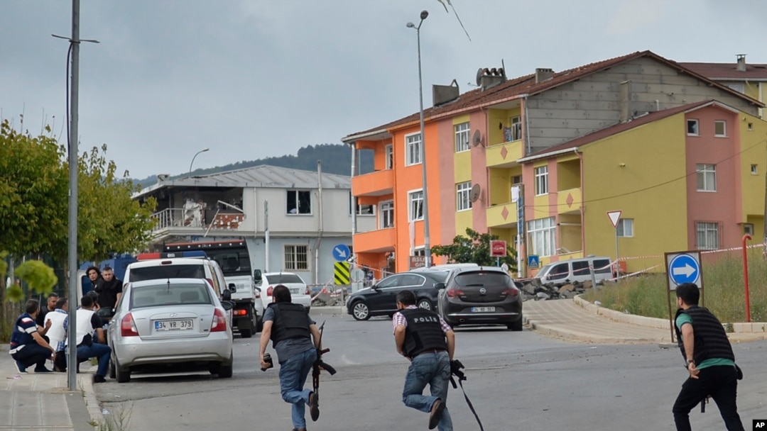 Polisi Turki berlarian mencari tempat berlindung saat terjadi tembak-menembak di dekat lokasi ledakan di sebuah kantor polisi di wilayah Sultanbeyli, Istanbul (10/8). 