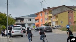 Polisi Turki berlarian mencari tempat berlindung saat terjadi tembak-menembak di dekat lokasi ledakan di sebuah kantor polisi di wilayah Sultanbeyli, Istanbul (10/8). 