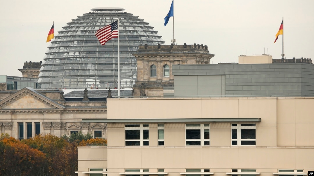 The U.S. flag flies on top of the U.S. embassy in front of the Reichstag building that houses the German Parliament, Bundestag, in Berlin, Germany, Oct. 25, 2013.