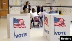 FILE - Voters receive their ballot to vote in the Super Tuesday election at Sleepy Hollow Elementary School in Falls Church, Virginia, March 1, 2016. 