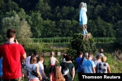 The blocky figure of Melania Trump was cut from the trunk of a living linden tree, whose base forms a tall plinth in a field beside the Sava River in Rozno, eight km (five miles) from Sevnica, Slovenia. July 5, 2019.