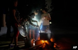 Residents prepare a soup over an open fire during a blackout following the failure of a major power plant in Havana, Cuba, Oct. 19, 2024.