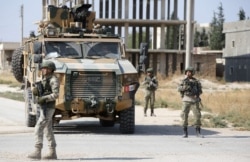 FILE - Turkish soldiers patrol the northern Syrian Kurdish town of Tal Abyad, on the border between Syria and Turkey, Oct. 23, 2019.