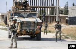 FILE - Turkish soldiers patrol the northern Syrian Kurdish town of Tal Abyad, on the border between Syria and Turkey, Oct. 23, 2019.