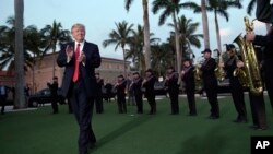 Presiden AS Donald Trump mendengarkan Palm Beach Central High School Band di Trump International Golf Club di West Palm Beach, Florida, yang akan dipakai untuk menjamu Perdana Menteri Jepang Shinzo Abe (5/2). 