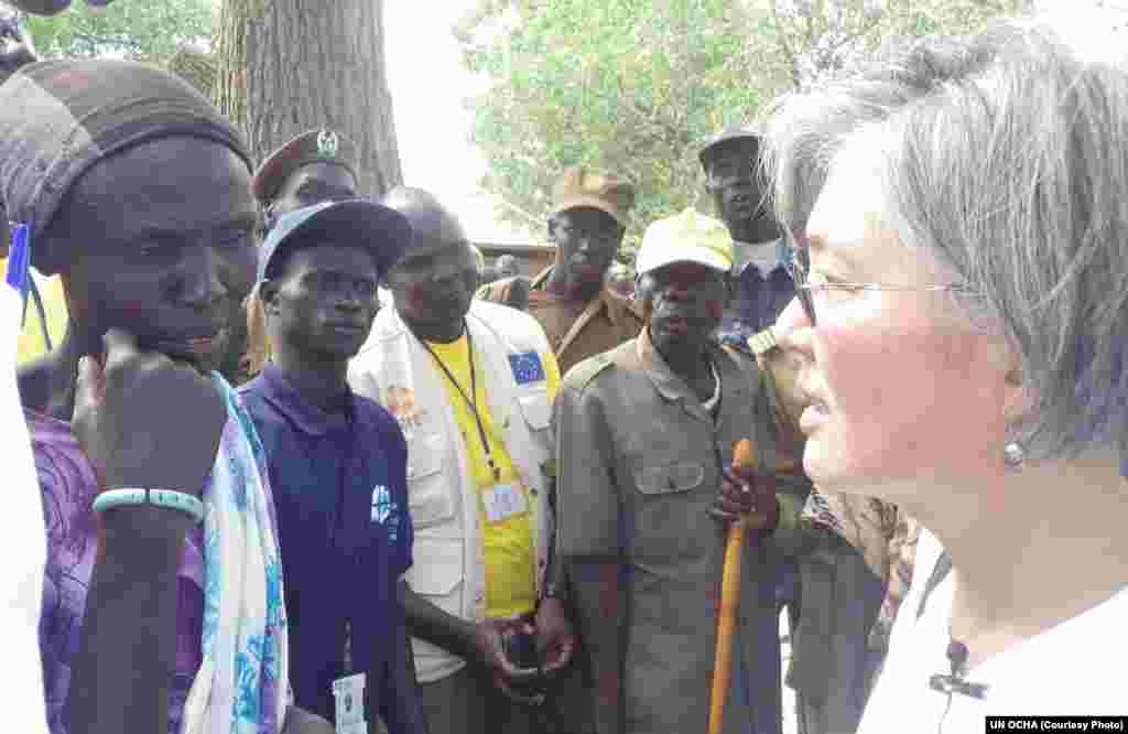 A woman in Twic East County tells the story of how her family was impacted by cattle raids as Kang (R.) listens.