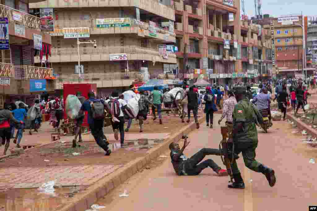 A police officer chases street vendors in Kampala, Uganda, after President Yoweri Museveni directed the public to stay home for 32 days due to the coronavirus pandemic.