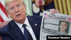 El presidente Donald Trump sostiene una copia del New York Post antes de firmar una orden ejecutiva para reducir las protecciones a las redes sociales.