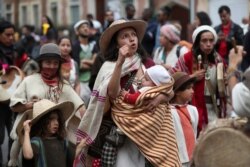 A woman marches with her children in an anti-government demonstration in Bogota, Colombia, Nov. 21, 2019..