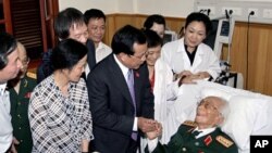 A September 2010 file photo shows Hanoi Communist Party chief Pham Quang Nghi (C-R) shaking hands with Gen. Vo Nguyen Giap in a hospital bed in Hanoi prior to start of celebrations for the city's 1,000th birthday