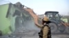 FILE - A police officer gestures as a bulldozer demolishes a property during a government demolition drive in Haldwani in the northern state of Uttarakhand, India, on Feb. 8, 2024.